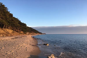 Photo of beach, water and cliiff